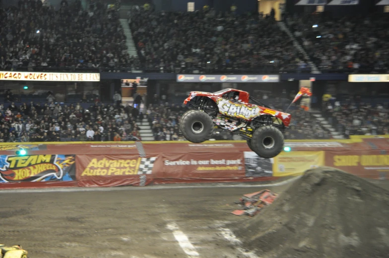 a monster truck is in mid air over a large hill