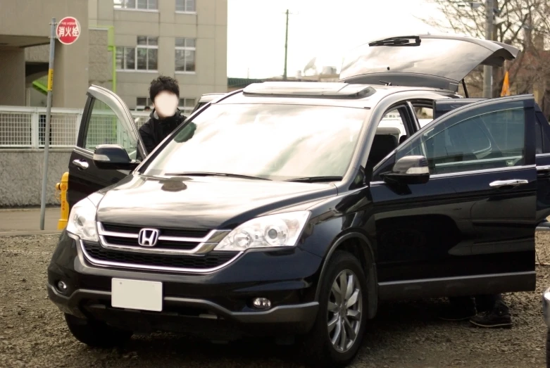 a car with two doors and three people walking by