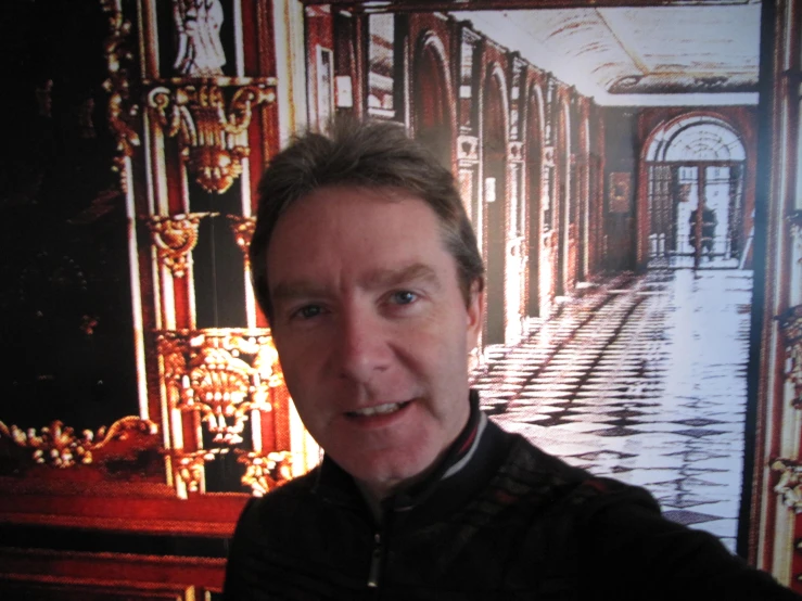 a man is smiling in front of the walls and columns