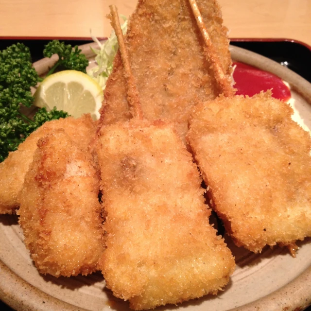 fried pieces of food with greens on the side