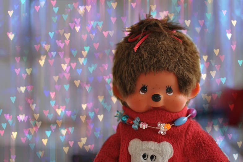 this doll has curly hair and wearing a red sweater