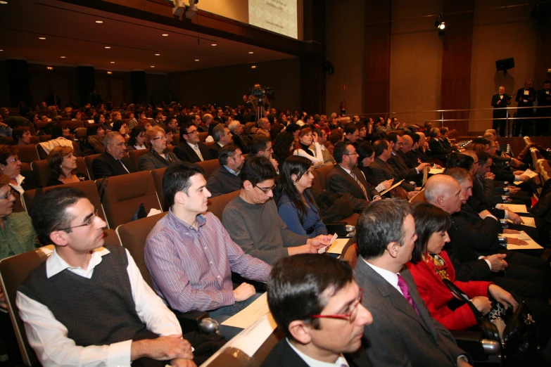 a large auditorium with many people sitting down