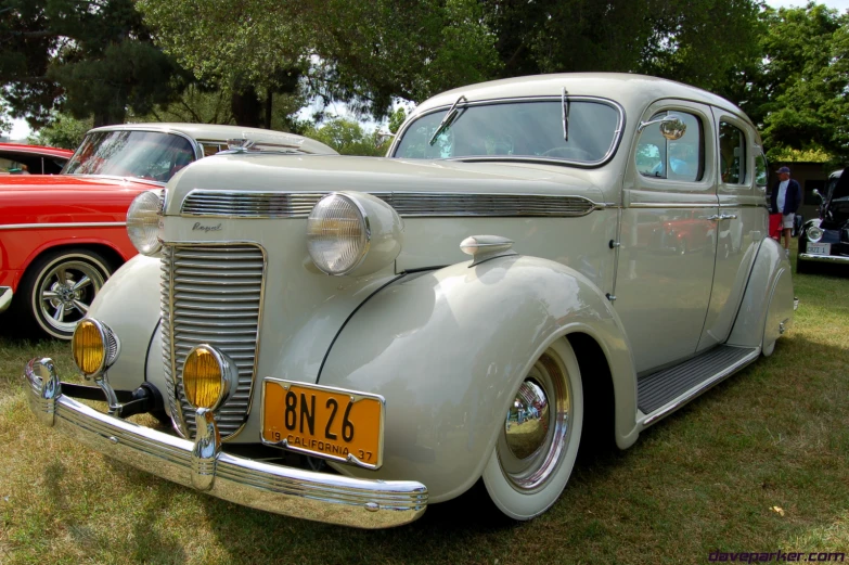 an old grey car parked in a field