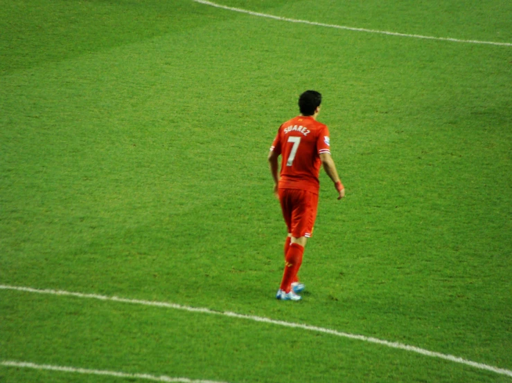 a soccer player in red playing on the field