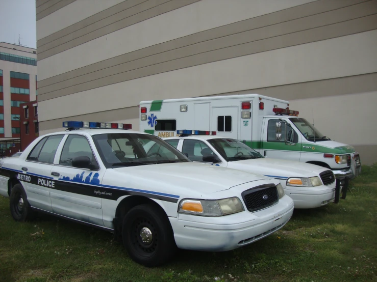 a line of police cars parked near some ambulances