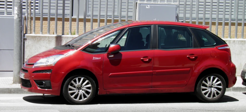 a red small car parked on the street