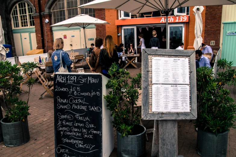 some potted plants are outside of a cafe