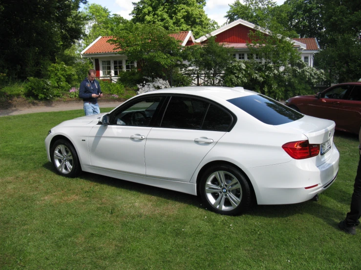 a white car is parked in the grass