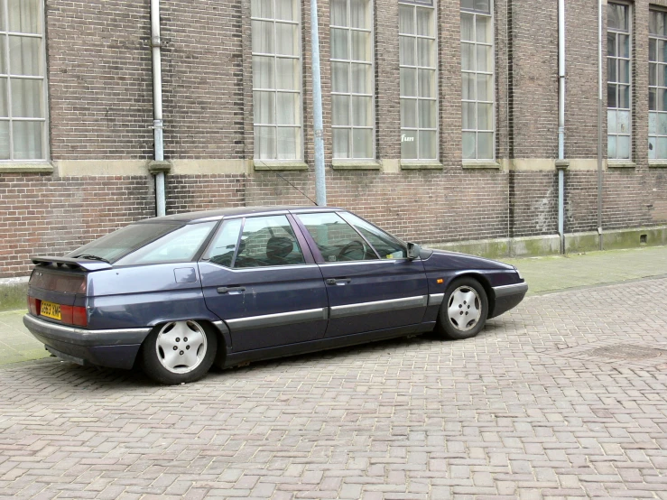 a blue parked car is on a brick street