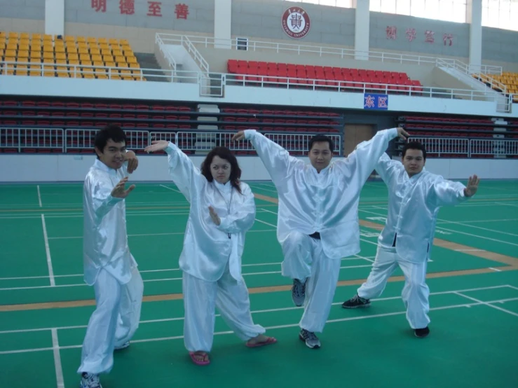 several people in white are standing on a green surface