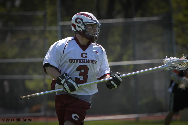 the player is running with his lacrosse stick