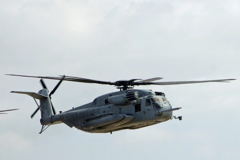 a large helicopter is flying high in the sky