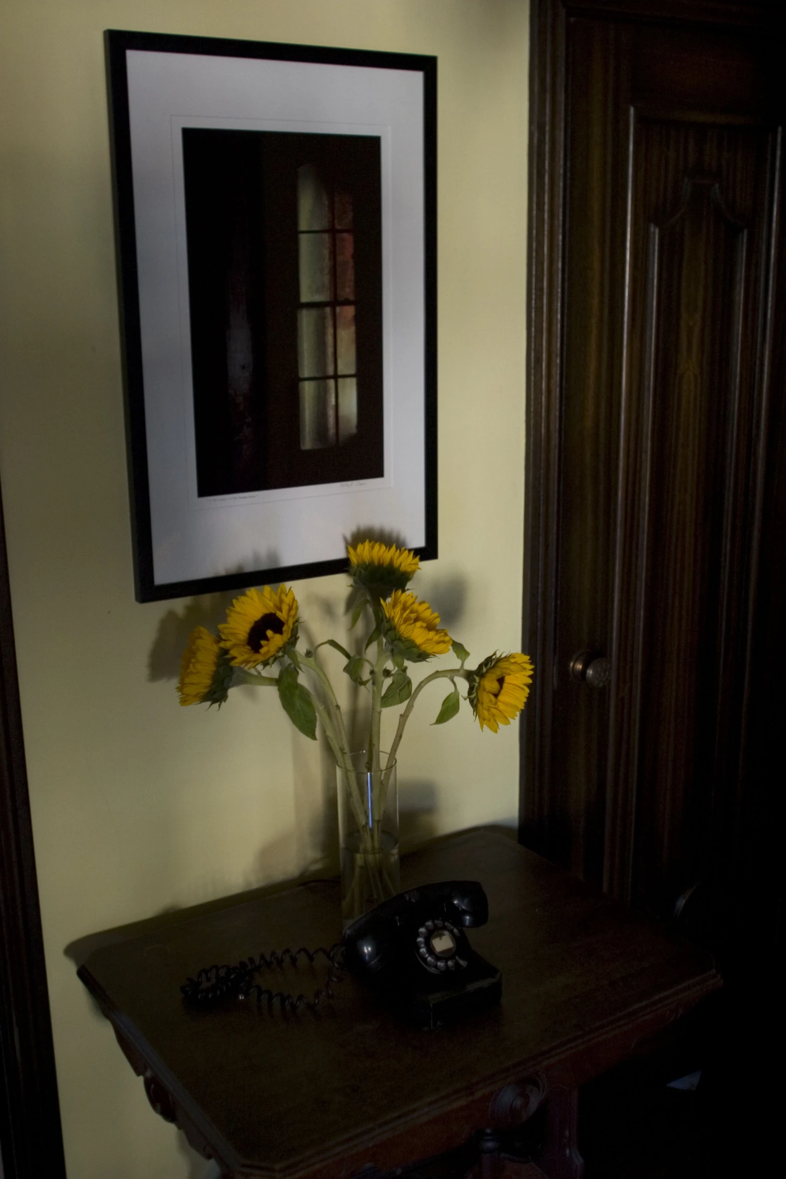 a vase with some yellow sunflowers on top of a table