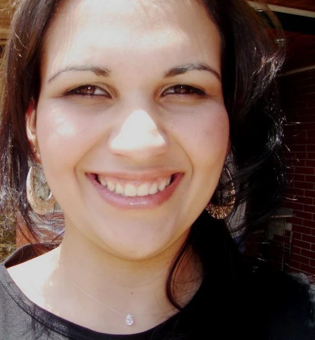 a woman with large brown eyes smiles for the camera