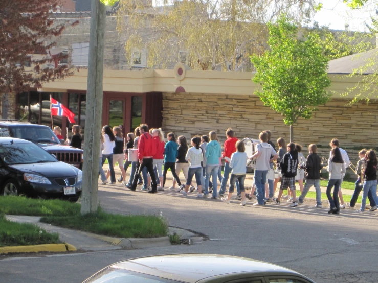 a group of people on the street walking along side cars