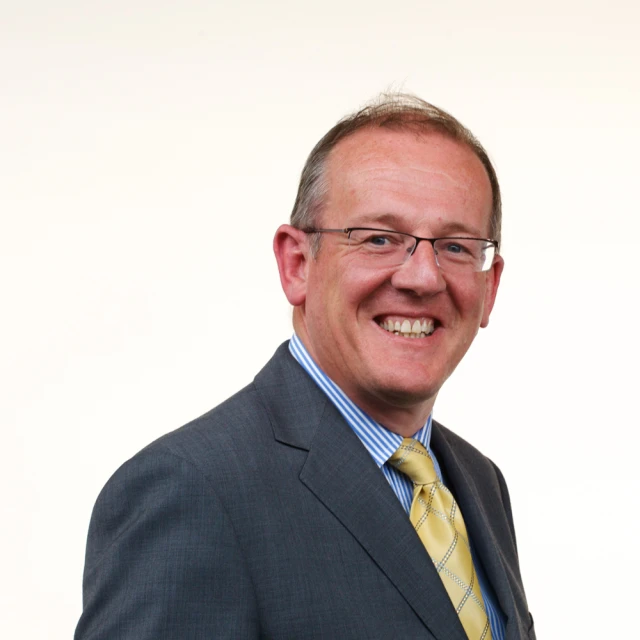 a man with glasses wearing a suit and tie