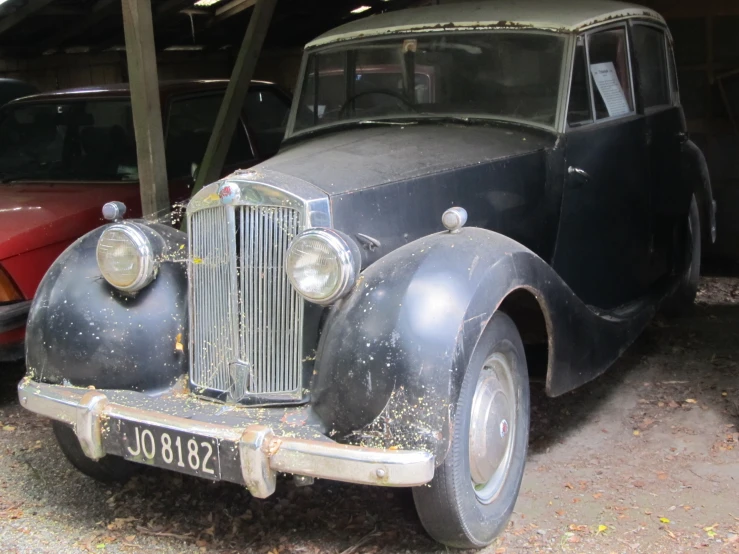 an antique vehicle parked in the garage near other cars