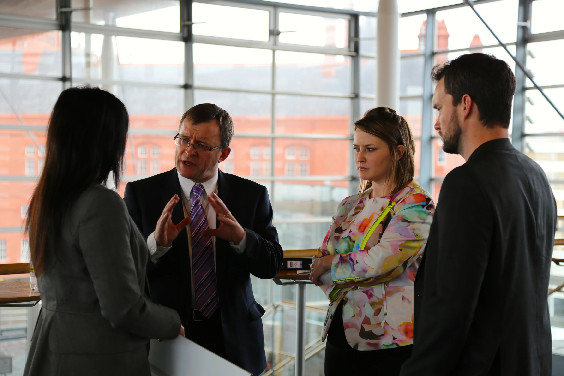 a man and three women are standing talking