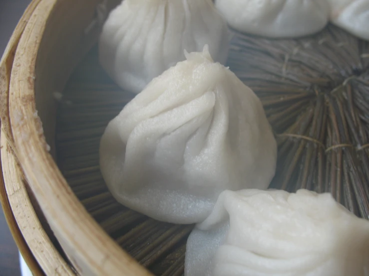 a close up s of several small dumplings in a bamboo steamer