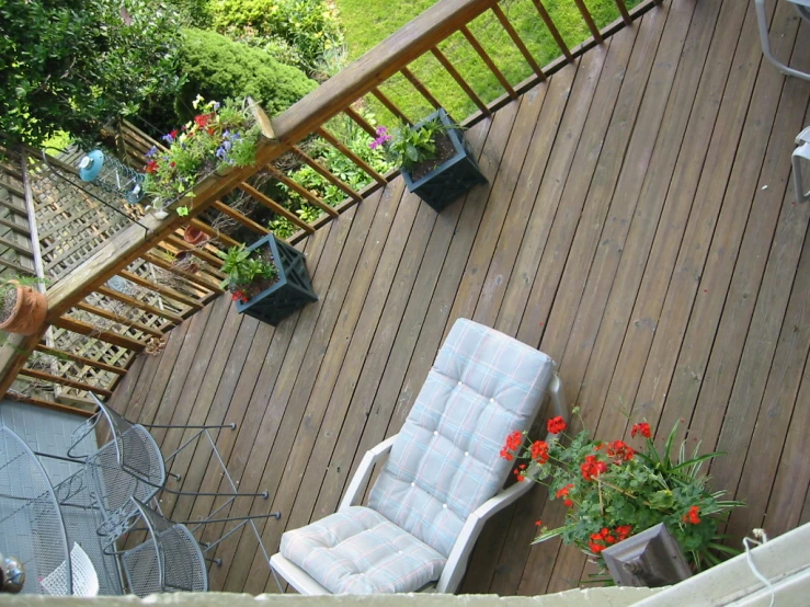 a wooden deck next to an open air grill