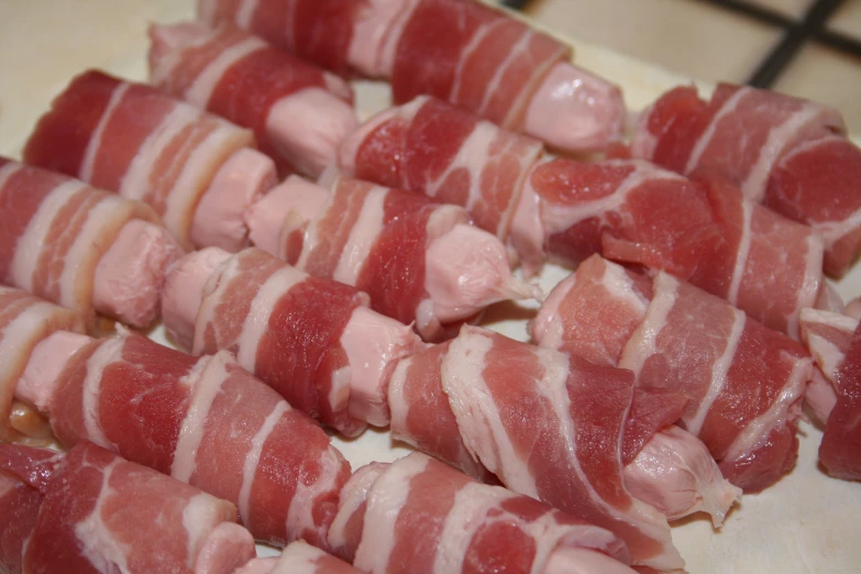 raw meats wrapped in bacon laying on top of a counter