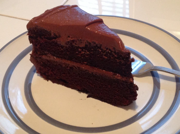 a slice of chocolate cake sitting on top of a white plate