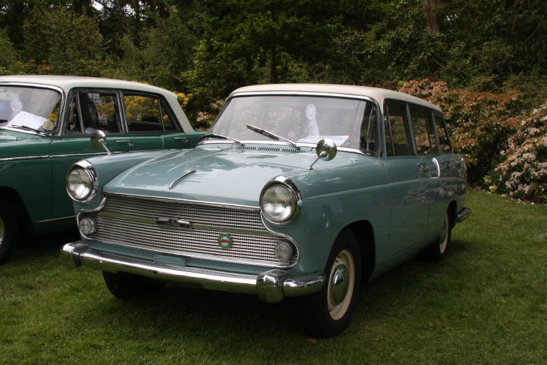 an old fashioned car parked in the grass