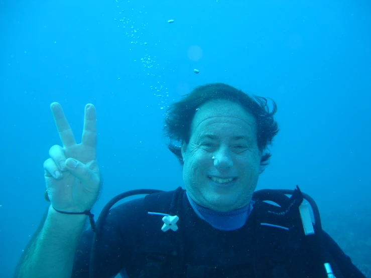 a man making the peace sign underwater