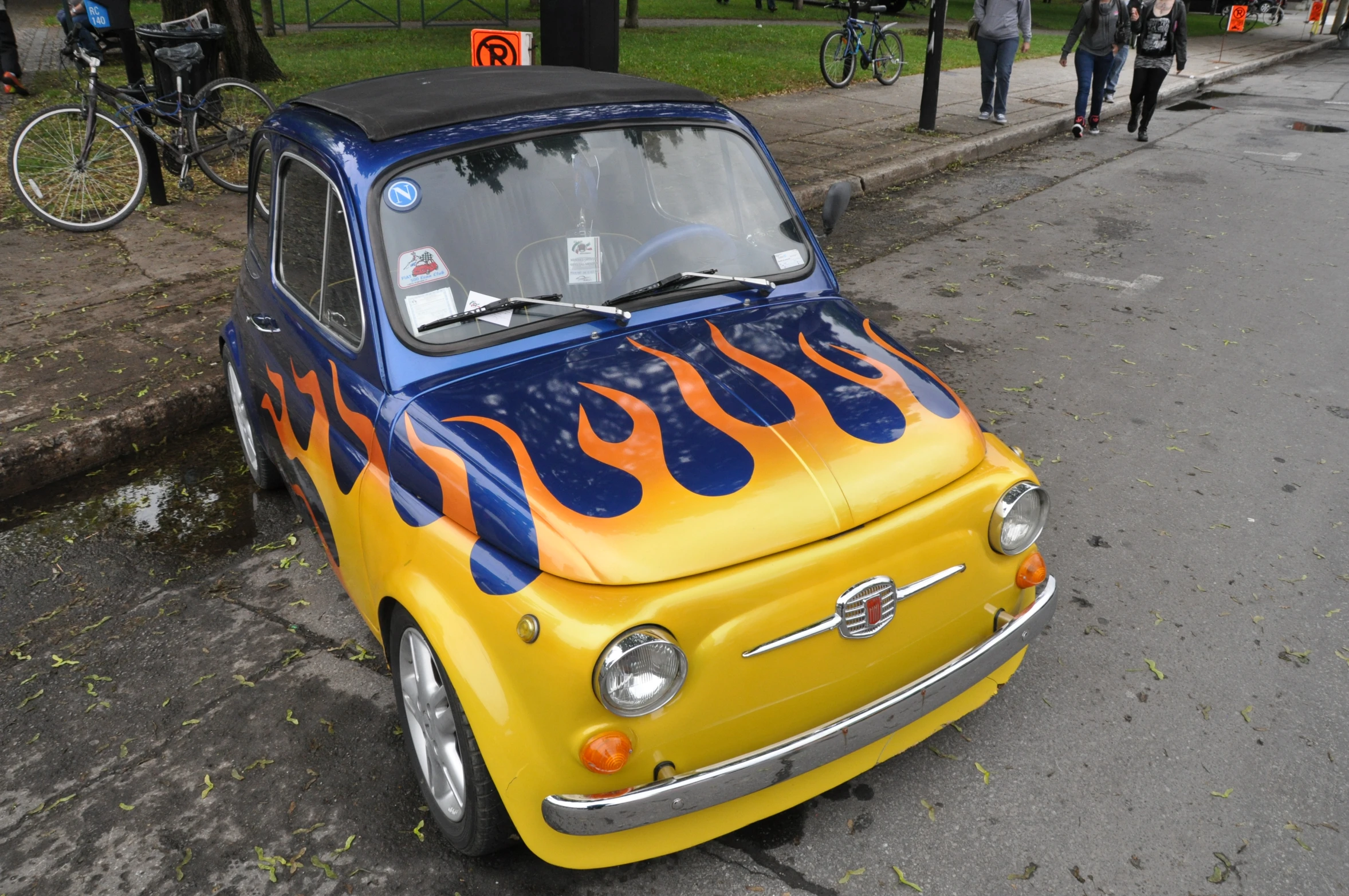 a small yellow car with flames painted on the hood