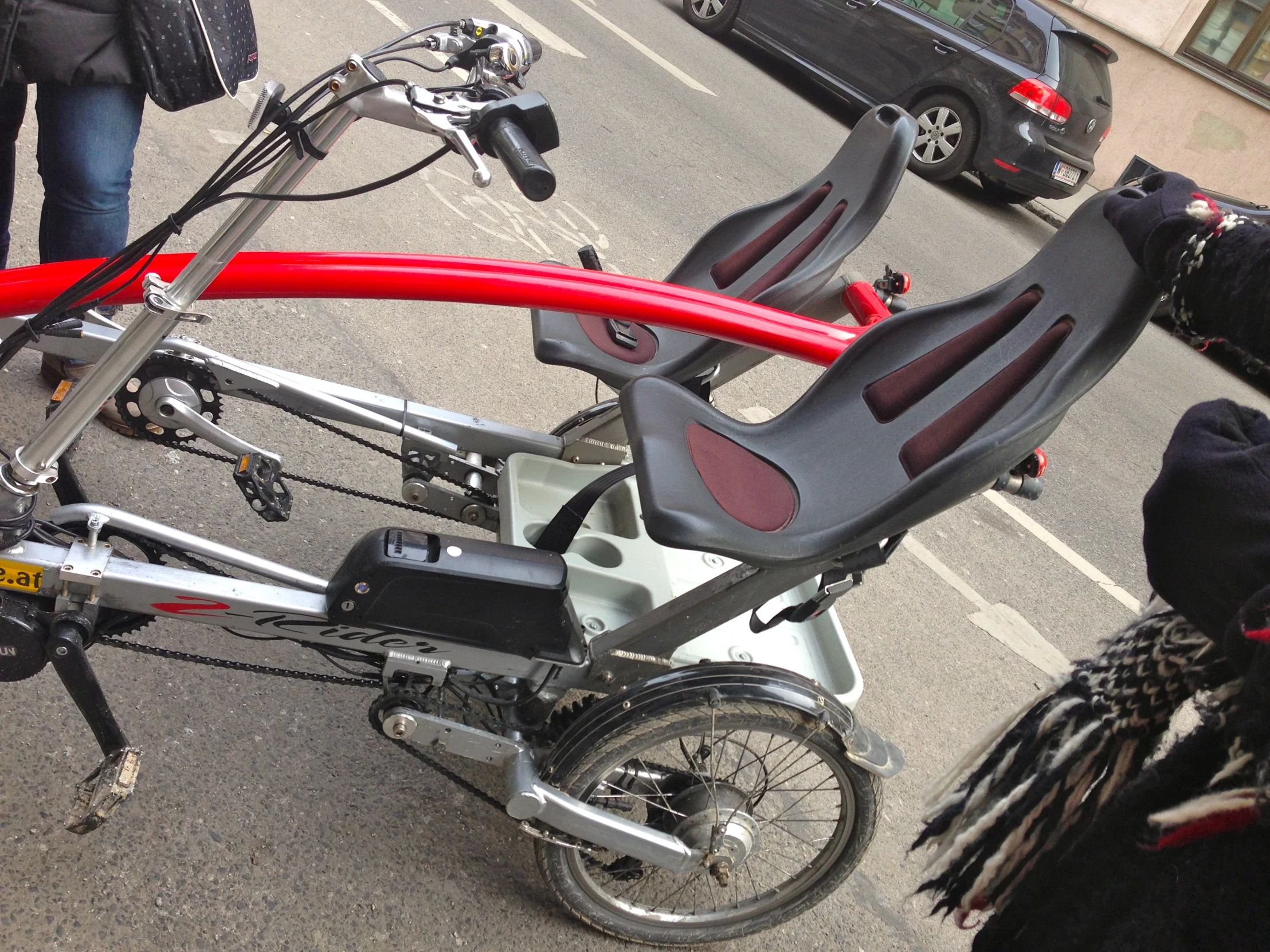 a red bike with seat and side mirror on the street