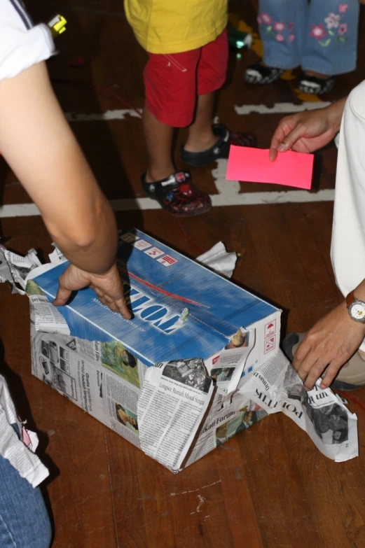 people looking through newspapers from above on wooden floor