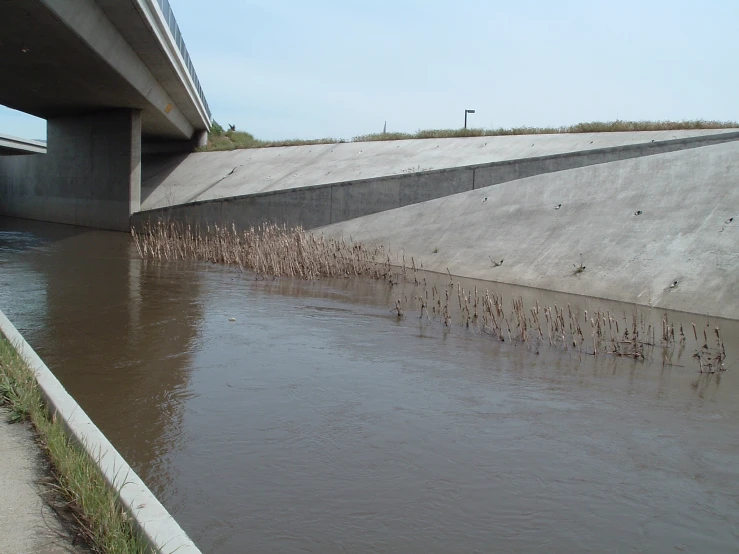 the side of an overpass and water on a river