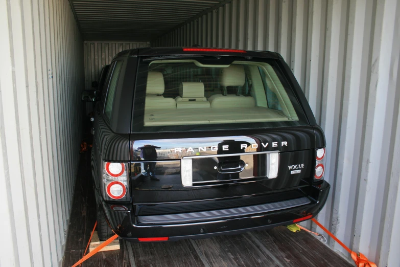 the side view of an suv being lowered from a container