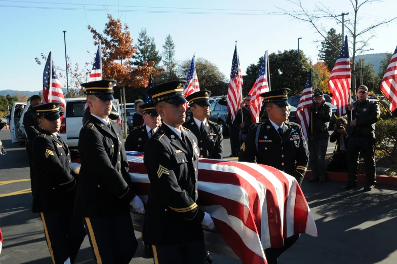 several men in uniform stand with their hands in the air holding a flag