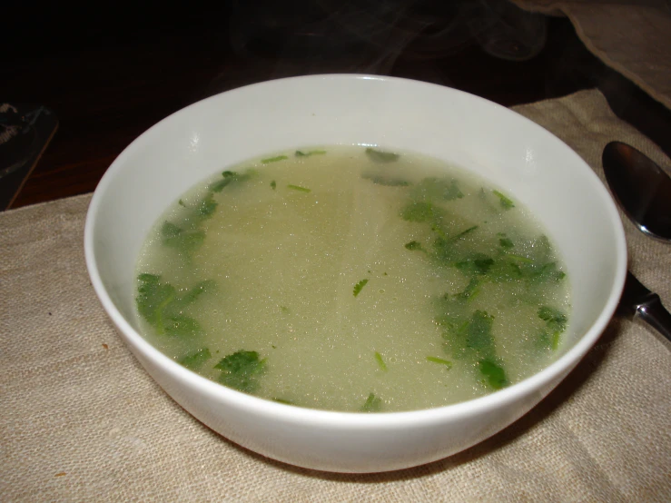 a bowl of broccoli soup sits on a table