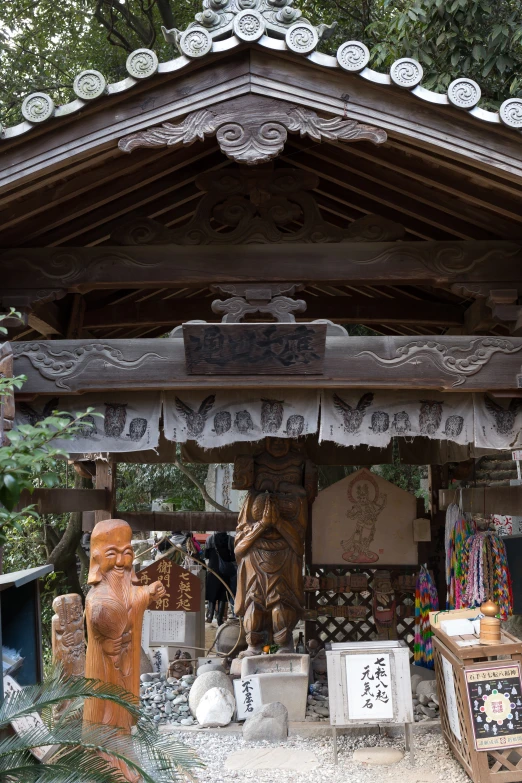 wooden statues and artwork under an oriental building