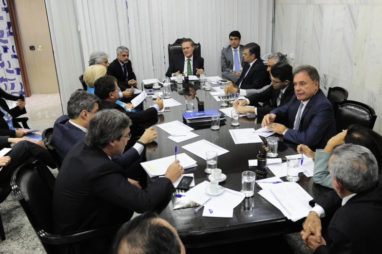 a group of business people sitting around a black table