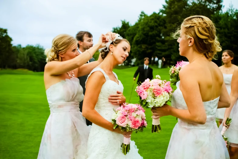 a bride gets ready for her wedding while groom waits for her