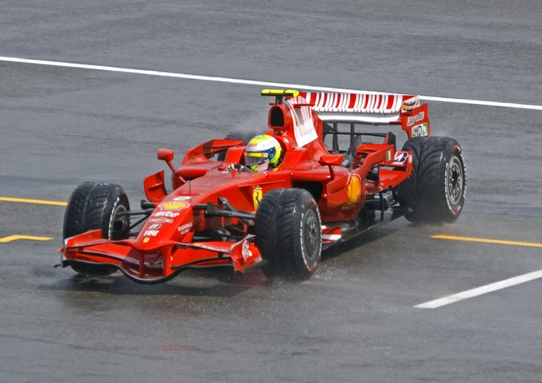 the front of a red race car that is being driven on a track