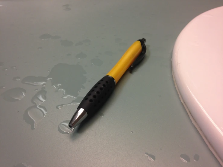 a small pen sitting on the ground in front of a sink