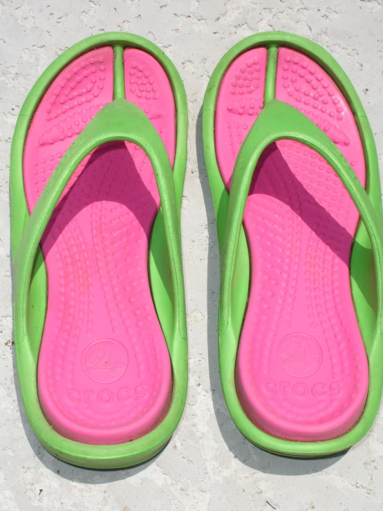 a pair of sandals with one in green and pink