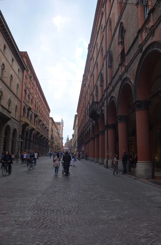 people are walking and riding bikes along a brick city street