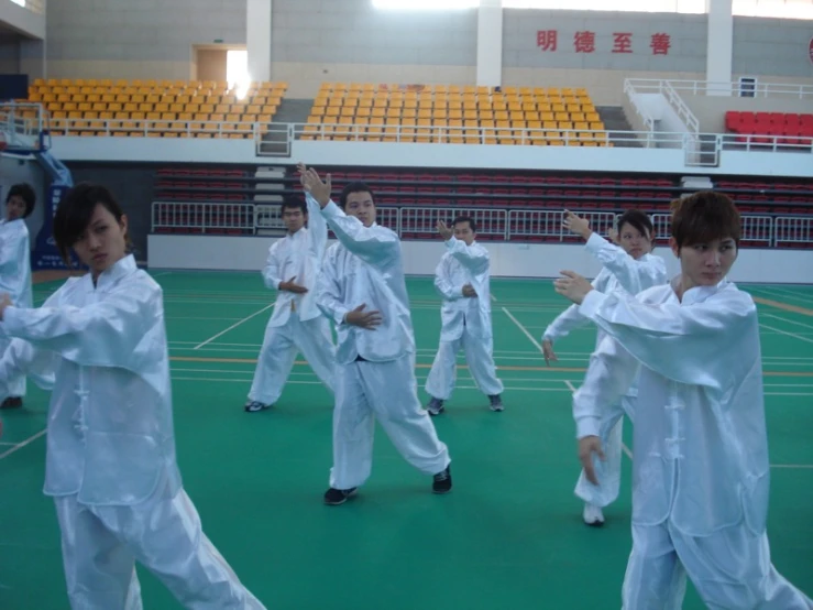 a group of s in white uniform standing on top of a green field