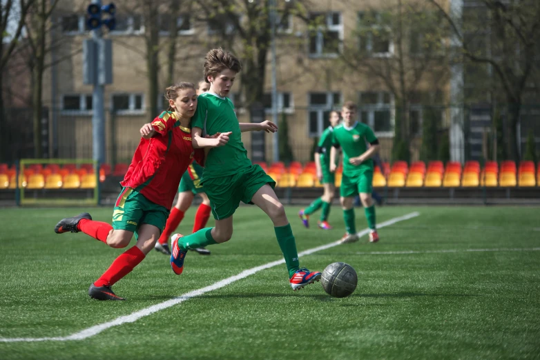 three girls playing soccer while one tries to get the ball