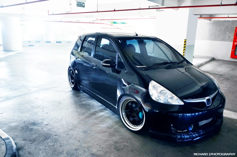 black car in a parking garage with white wheels