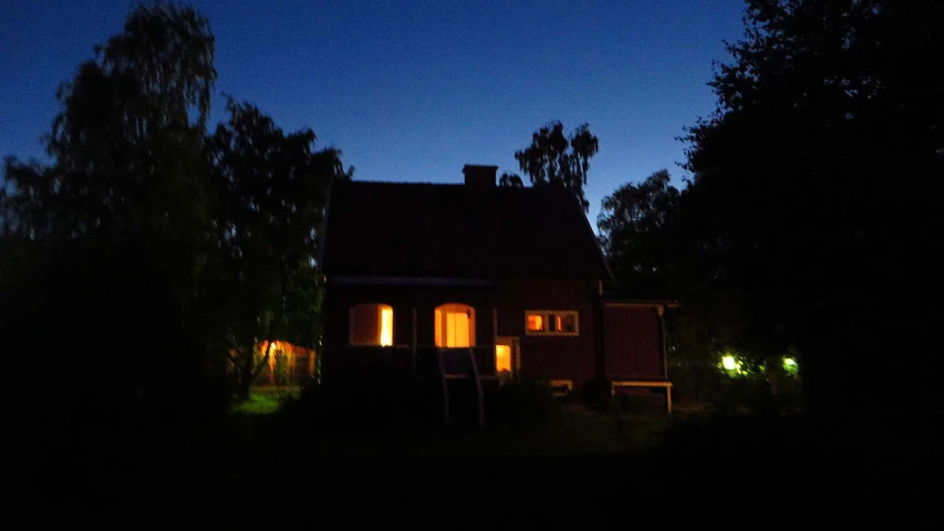 the outside of a house lit by candlelights