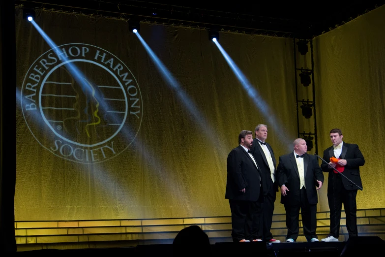 a group of men are standing on stage