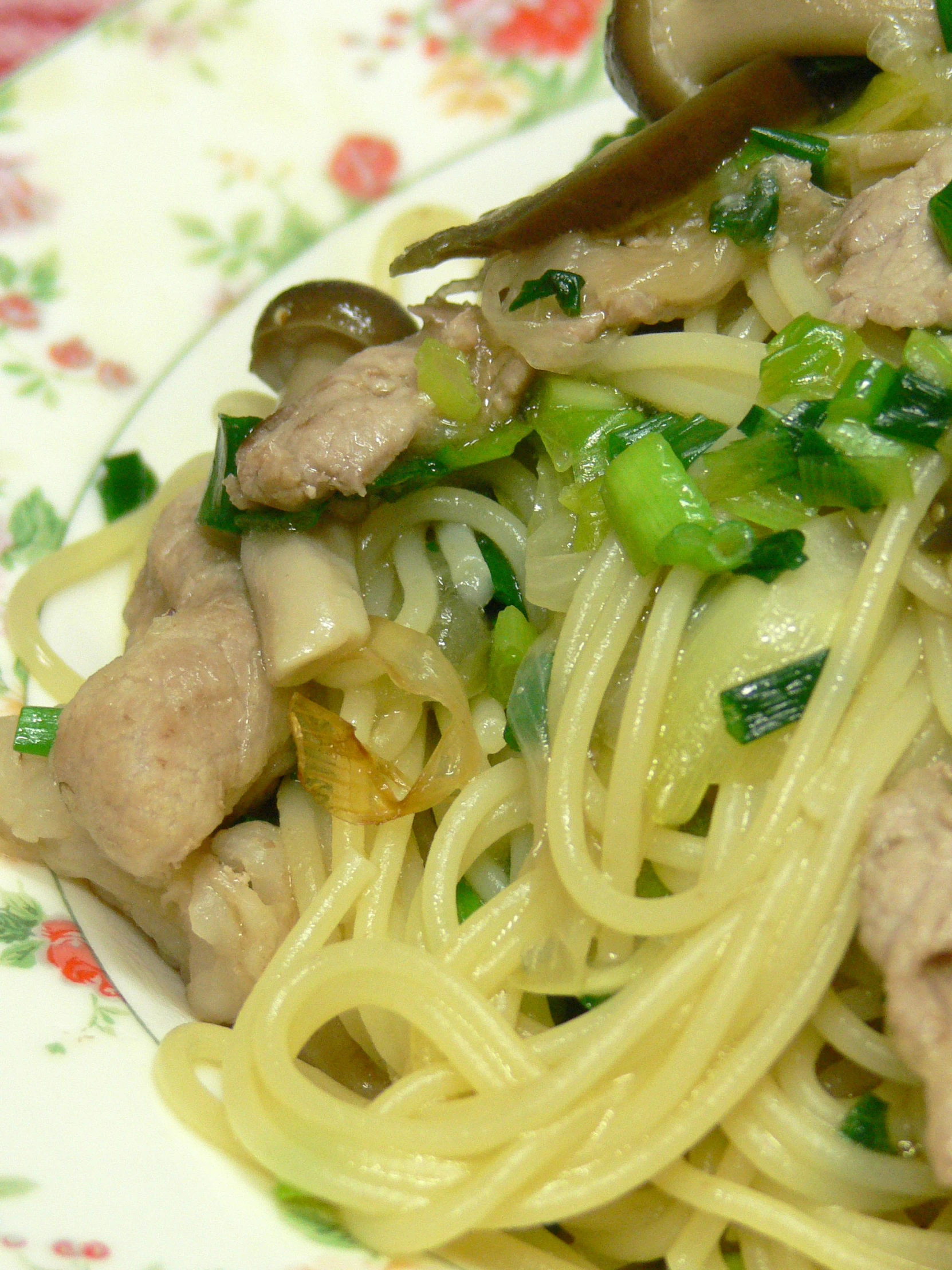 plate with noodles and green vegetables and meat on it