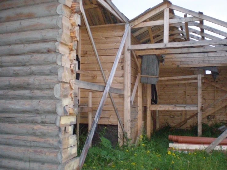 a wooden building has two wooden poles next to the doorway