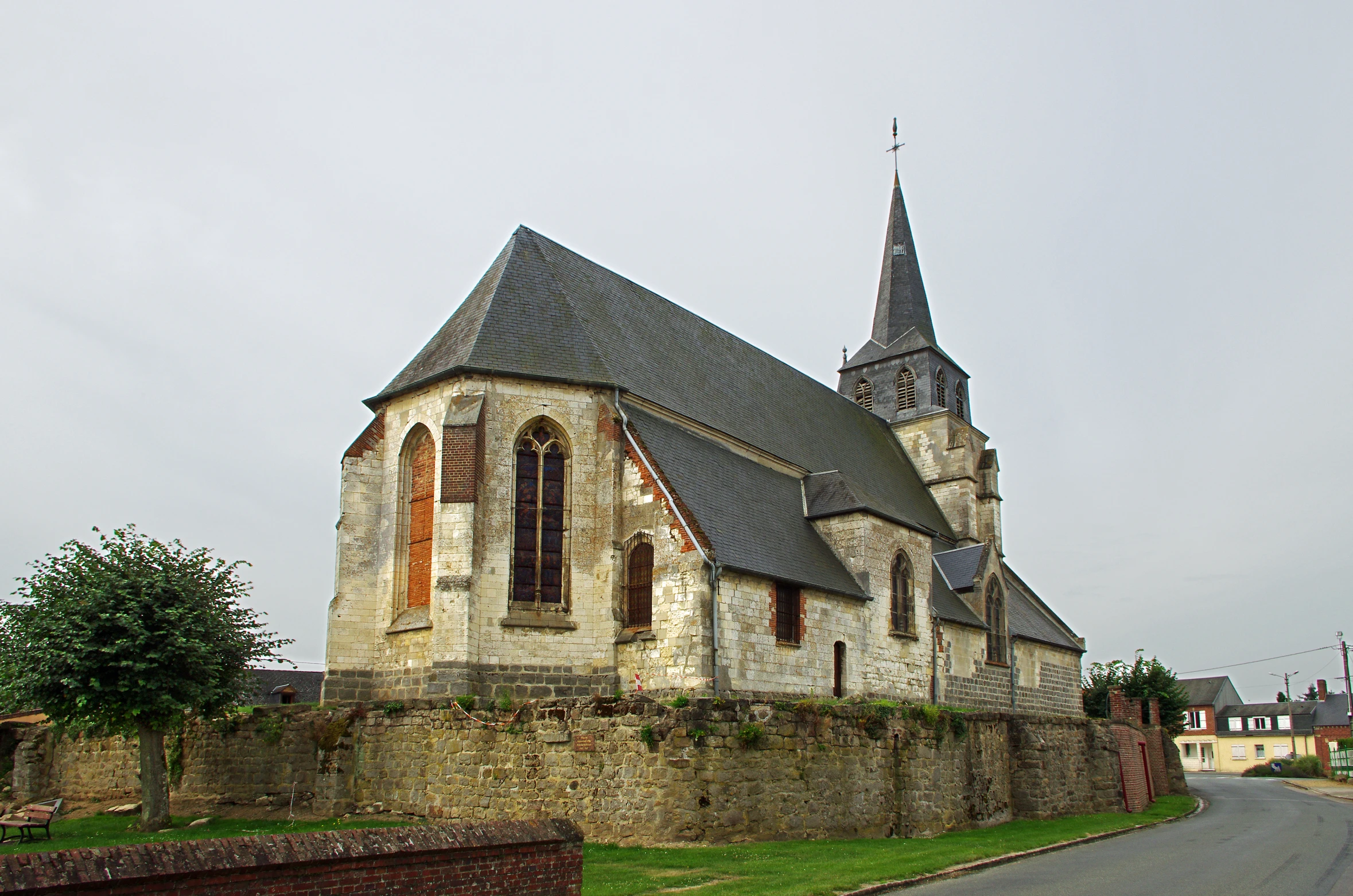 an old church with an old steeple is next to a road